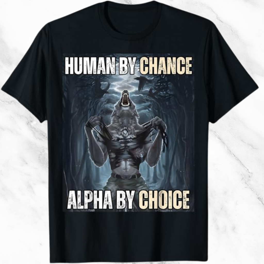 A black t-shirt with the words "Human By Chance Alpha By Choice" and an anthropomorphic wolf with a humanoid body kneeling in a forest at night. The wolf has a wolf's head and fur-covered torso and is tearing through a black shirt with its claws. Its mouth is open, and it appears to be howling. The background includes trees, mist, and crows flying overhead. The wolf is wearing green military-style pants.
